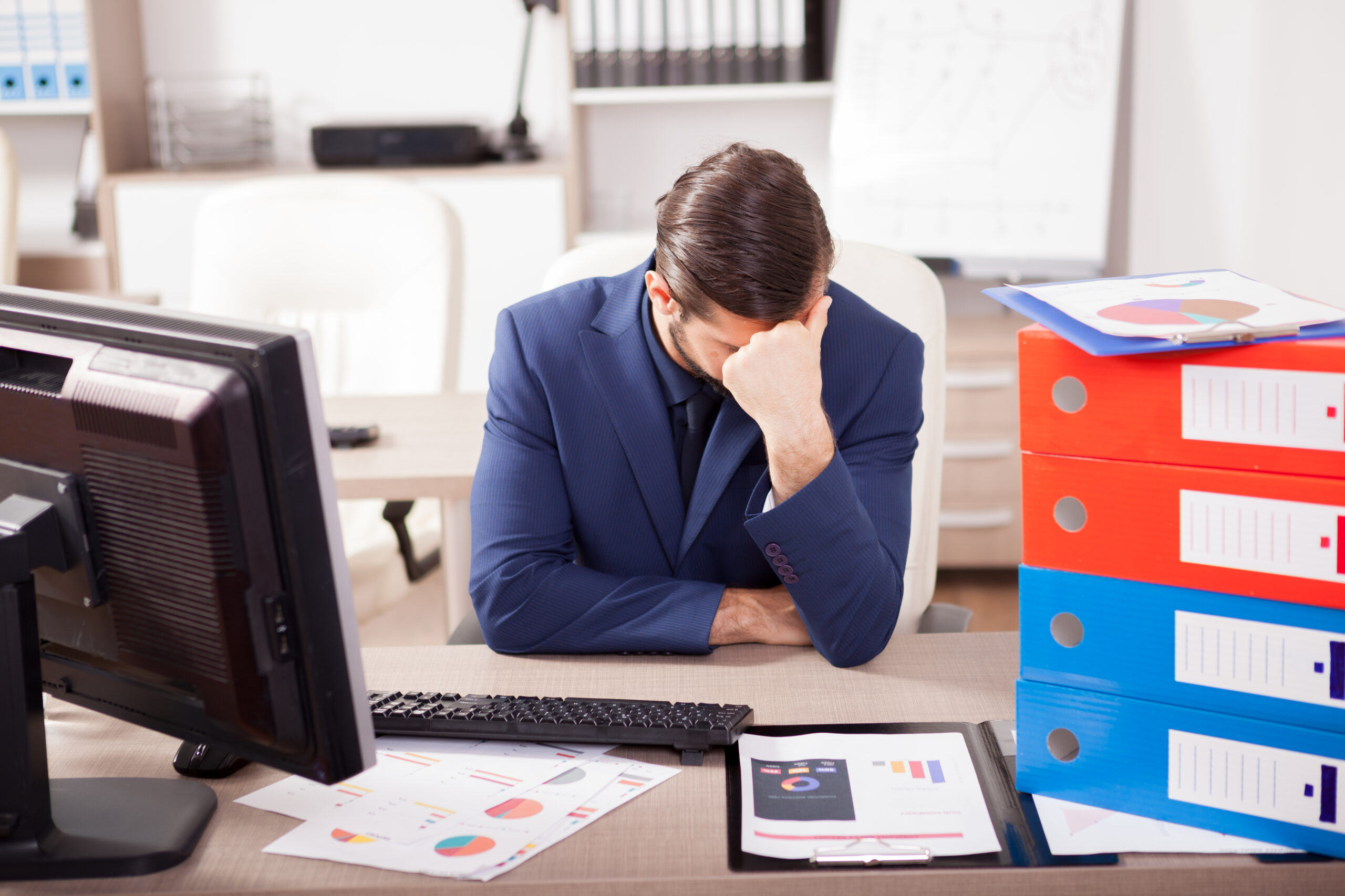 overspannen man op werk aan bureau 