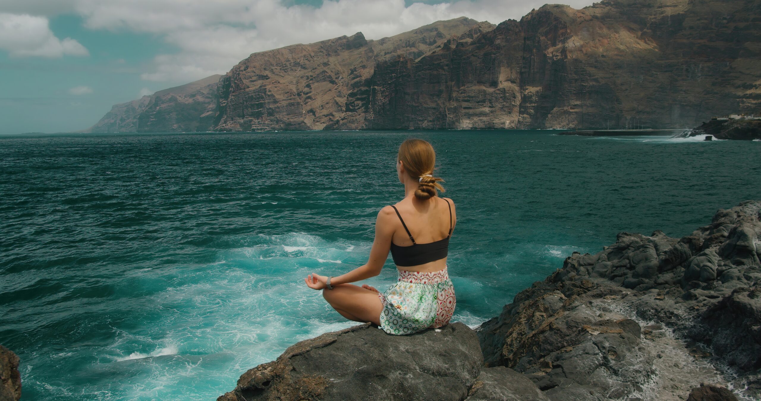 mindfulness vrouw mediteren bij de zee op een rots