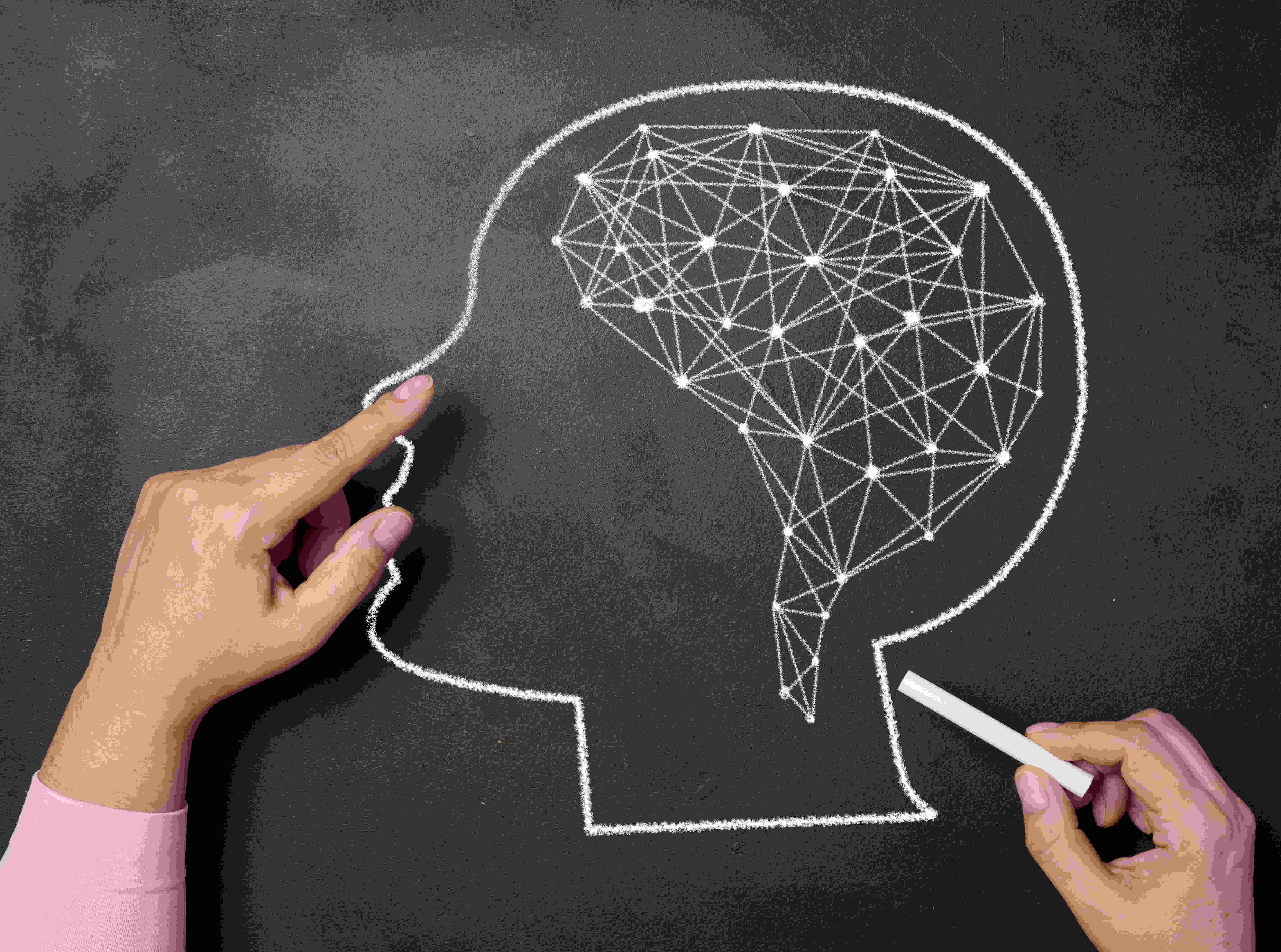 A woman's hand draws a silhouette of the head and connections in noradrenaline in brein