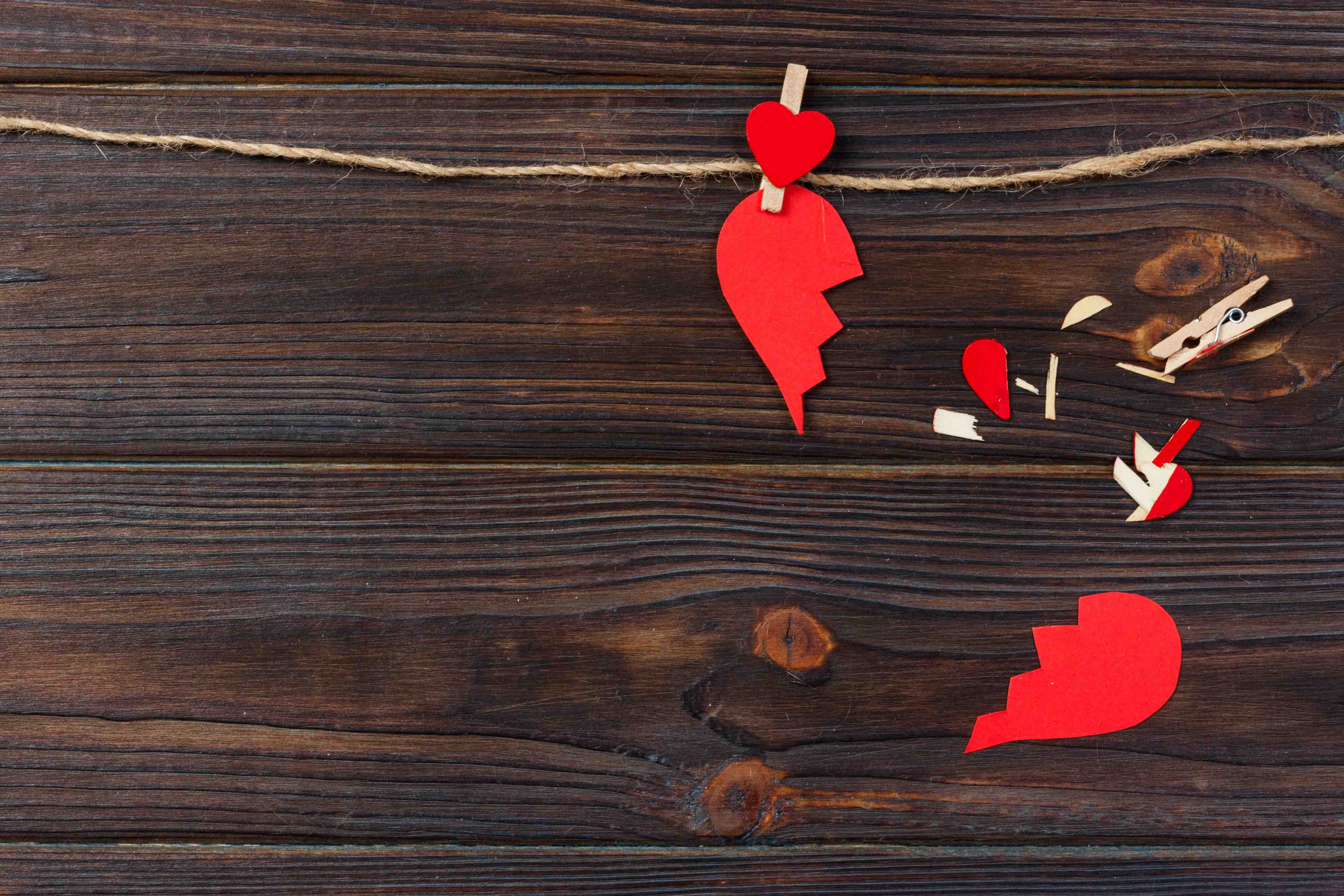 Broken heart breakup collection and divorce icon. Red paper shaped as a torn love , health care problems due to illness. Broken love concept gebroken hart pijnlijk en verdrietig