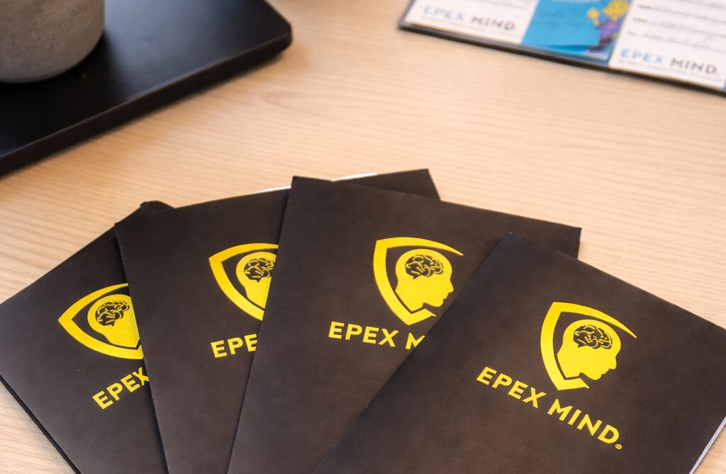 EpexMind brochures op houten bureau mentaal gezond onderwijs meeting